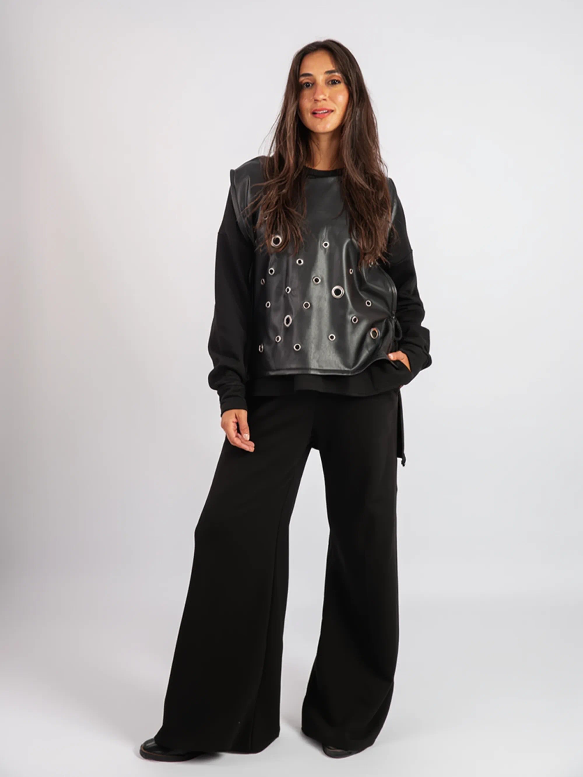 Woman wearing a black outfit with a unique top on a white background