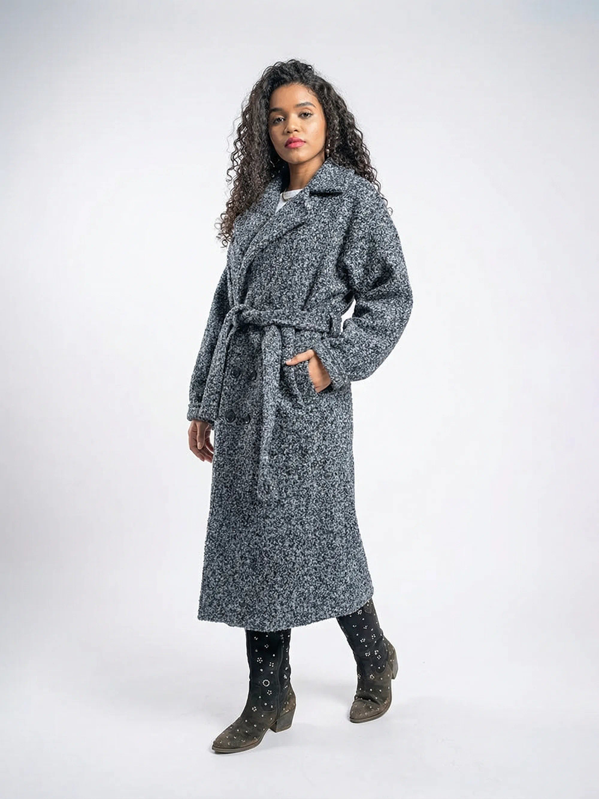 Woman wearing a long gray coat on a white background