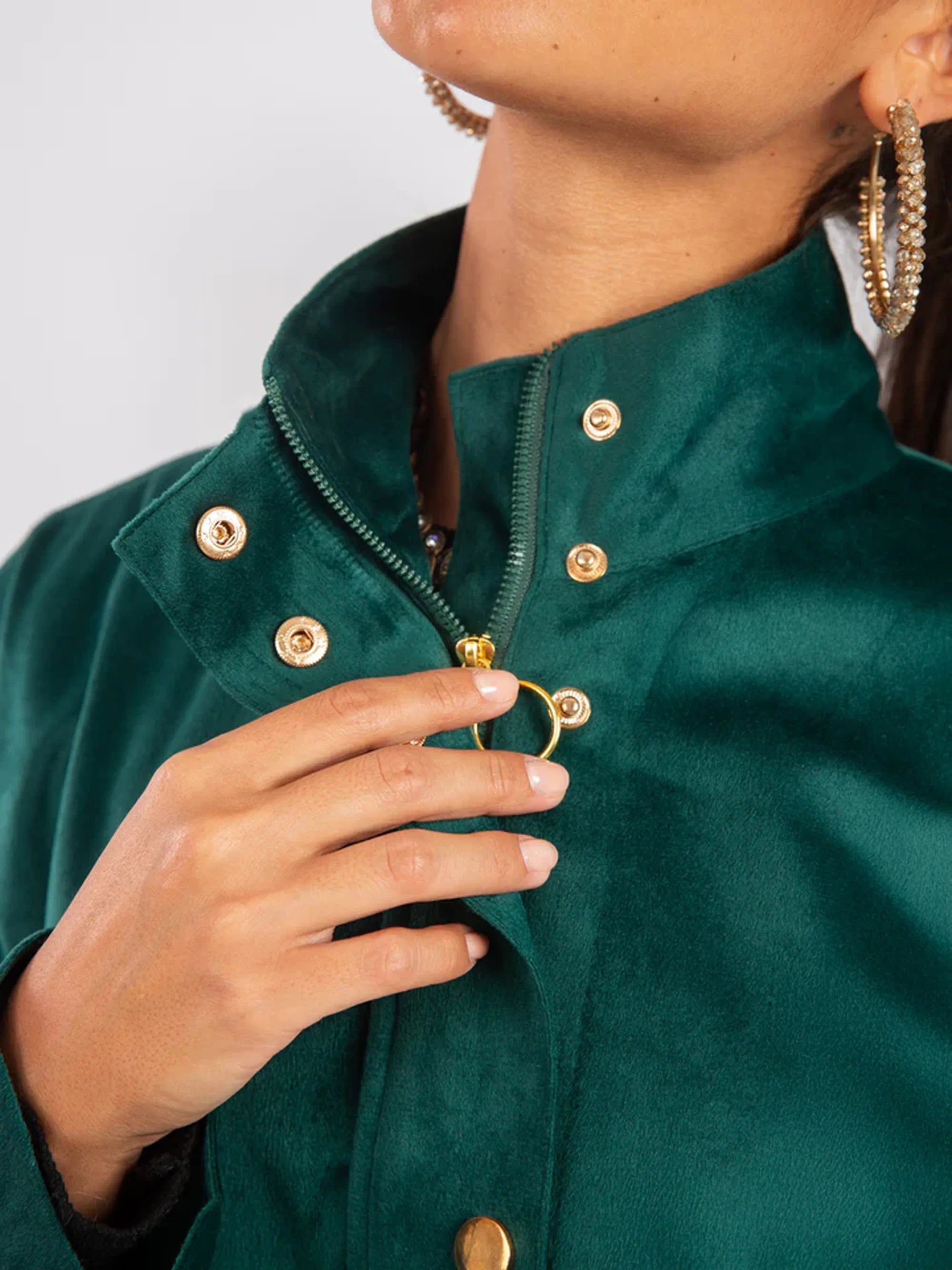 Close-up of a person wearing a green jacket with gold buttons.