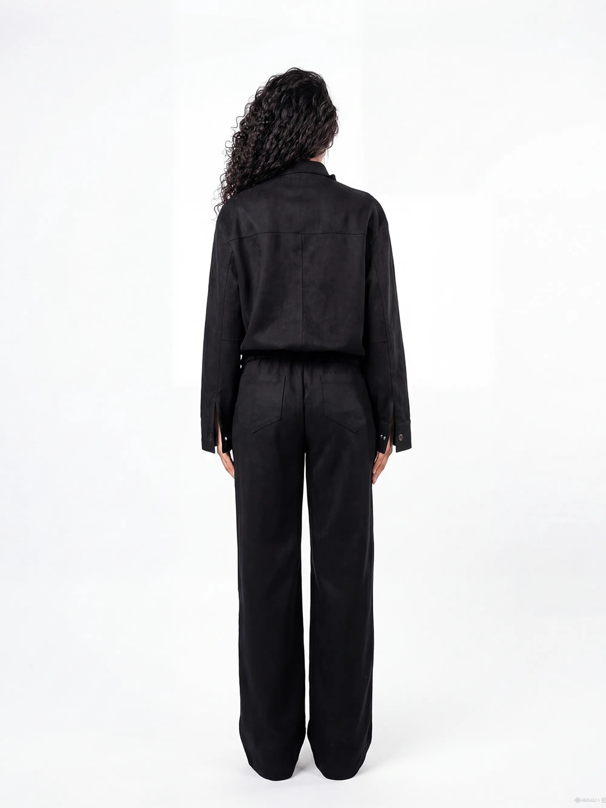 Person wearing a black jumpsuit on a white background