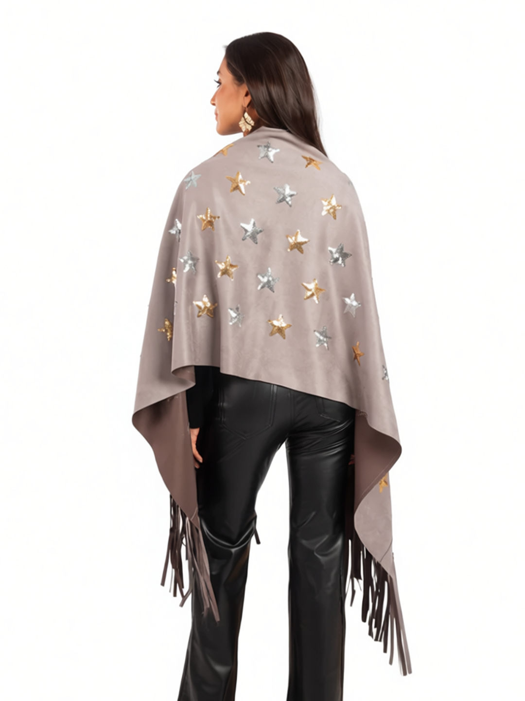 Woman wearing a beige poncho with star patterns and fringes on a white background