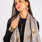 Woman wearing a gray scarf with star patterns on a white background