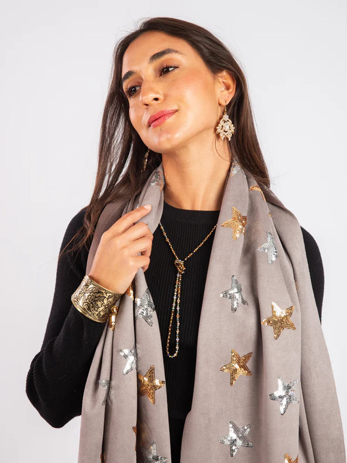 Woman wearing a gray scarf with star patterns on a white background