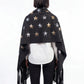 Person wearing a black star-patterned shawl with fringes on a white background