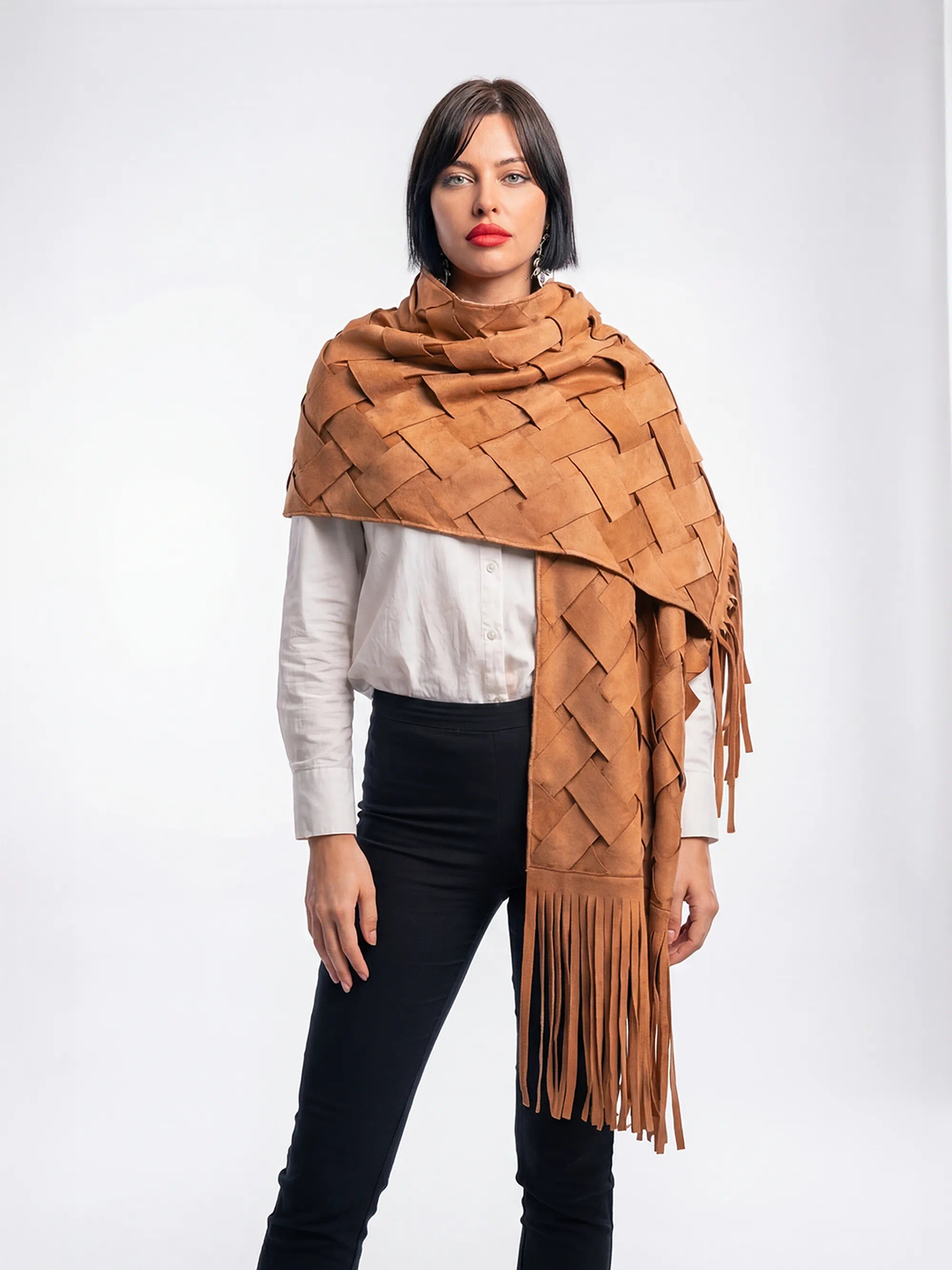 Woman wearing a brown woven scarf with fringe on a white background