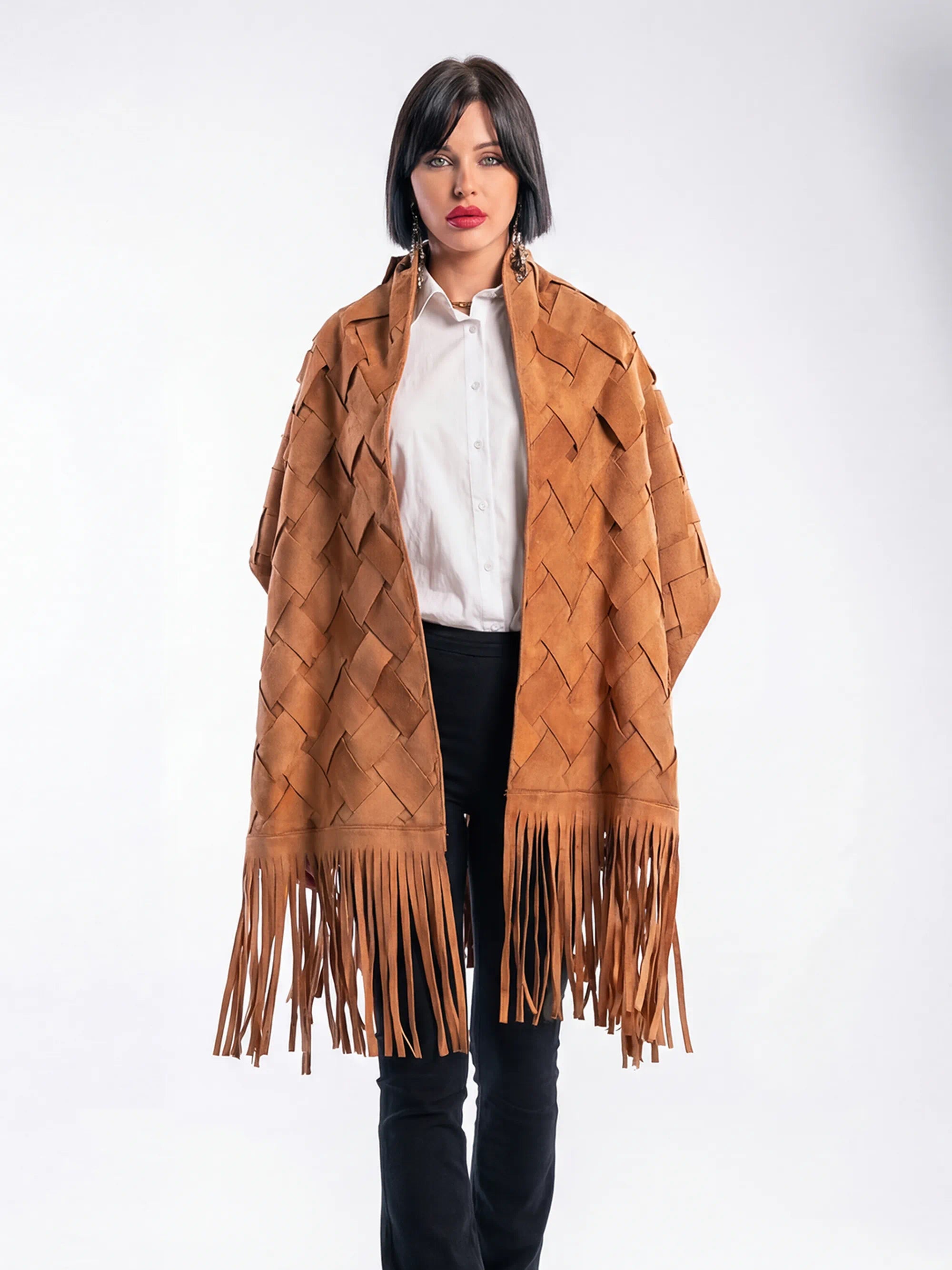 Woman wearing a brown fringed poncho against a white background